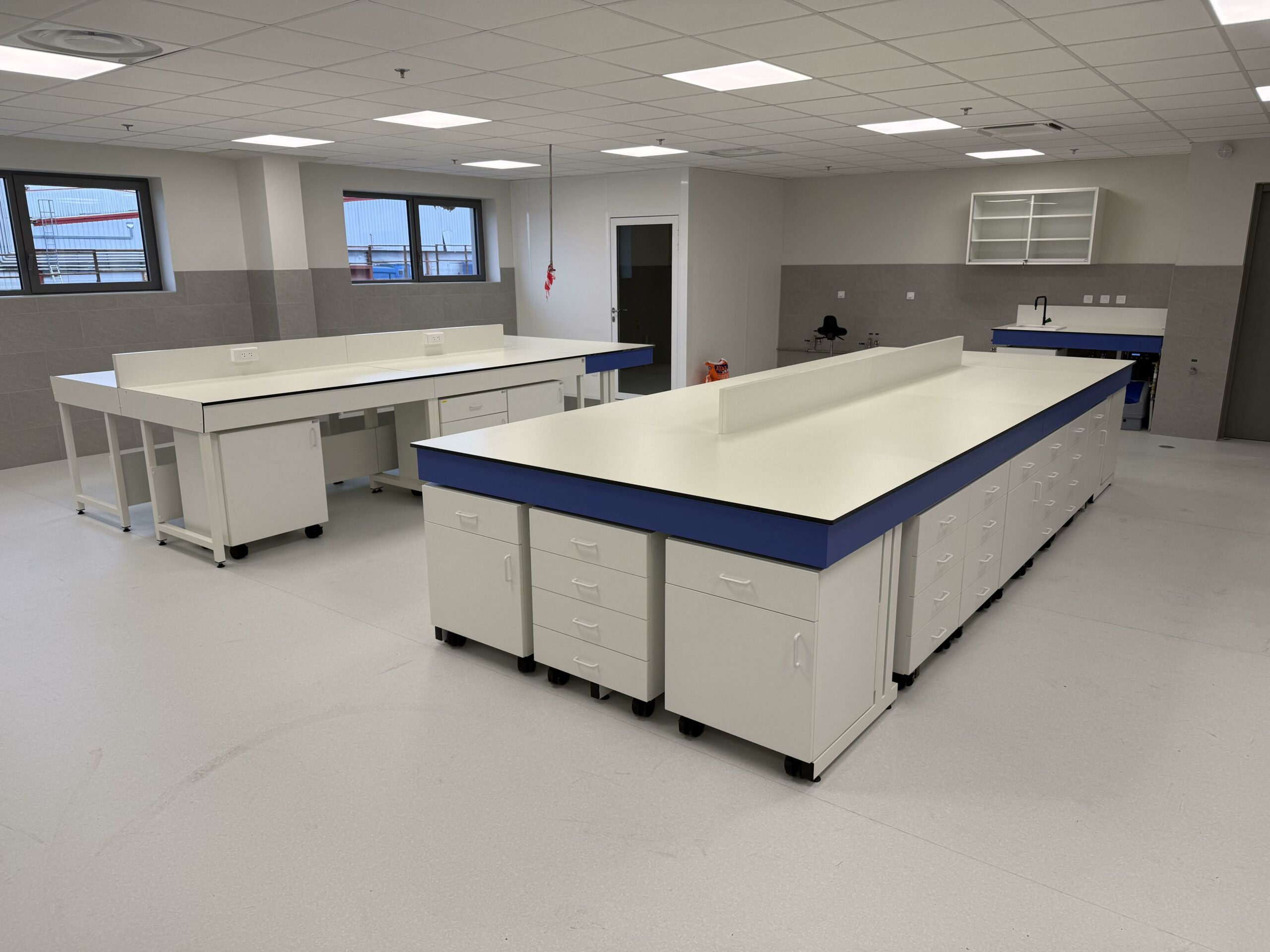 Paillasses centrales de laboratoire sur mesure avec plan de travail en Trespa et rangements intégrés dans la Drôme